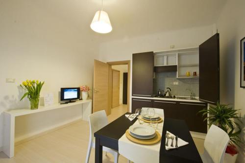a living room with a dining table and a kitchen at Vico Amato Residenza in Sulmona