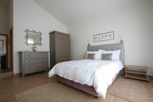 1 dormitorio con cama, tocador y espejo en Banda Do Sol Self Catering Cottages, en Estreito da Calheta
