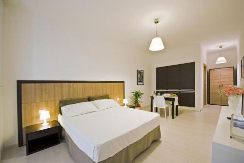 a bedroom with a large bed and a dining room at Vico Amato Residenza in Sulmona