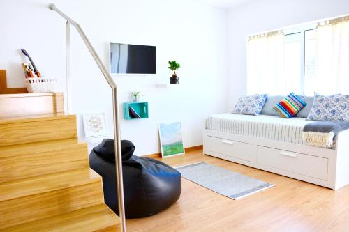 Una sala de estar con una cama y una otomana negra. en Porto Garden Villas | Downtown, en Vila Nova de Gaia