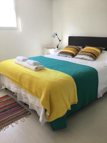 a bedroom with two beds with yellow and blue sheets at Casa Finisterre in Puerto Pirámides