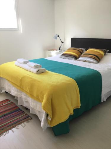 1 dormitorio con 2 camas con sábanas amarillas y azules en Casa Finisterre, en Puerto Pirámides