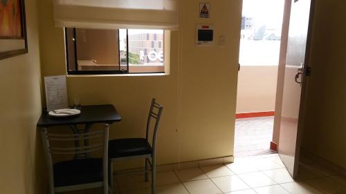 a small table and chairs in a room with a window at Suites Larco 656 Miraflores Lima in Lima