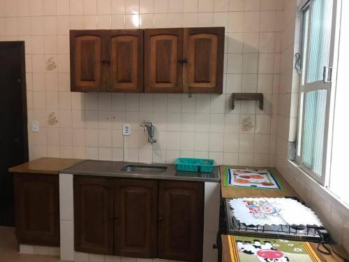 - une cuisine avec des placards en bois et un comptoir dans l'établissement Pousada Coração de Jesus, à Aparecida