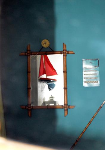 a wooden shelf with a toy sailboat on a wall at Hotel Auberge des Remparts in Laval