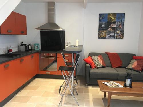 un salon avec un canapé et une cuisine dans l'établissement Au Coeur de Nuits, à Nuits-Saint-Georges