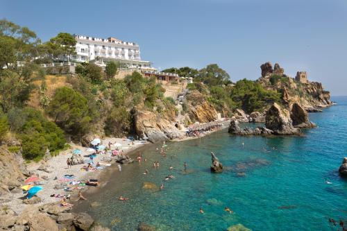 a group of people in the water at a beach at Hotel Kalura in Cefalù