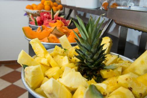 a bowl of fruit with a pineapple on top of it at Hotel Rossini 4S in Lignano Sabbiadoro