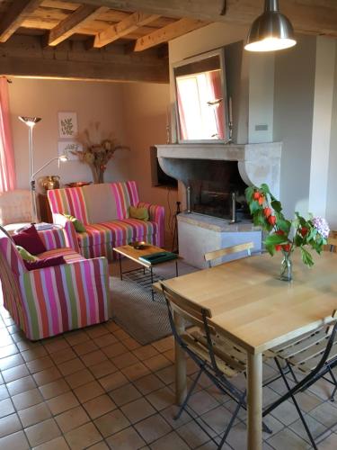 a living room with a table and a fireplace at Coeur De Beaujolais in Corcelles-en-Beaujolais