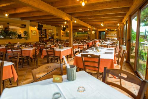 een eetkamer met tafels en stoelen in een restaurant bij Hotel La Tavola Rotonda in Assisi