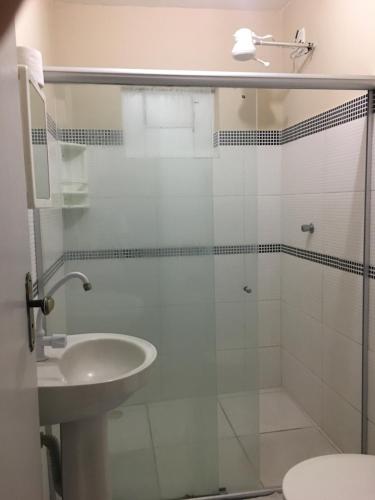 a bathroom with a glass shower and a sink at Hotel Real Jequie in Jequié