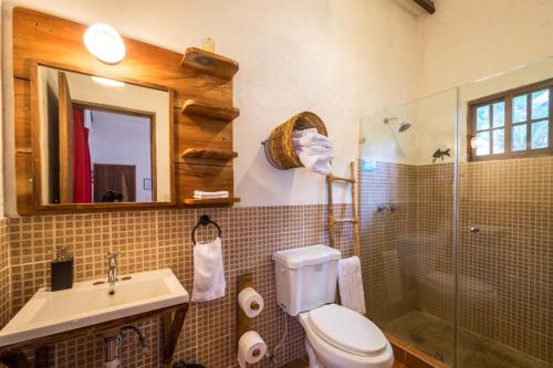 a bathroom with a toilet and a sink and a shower at Istmo Beach and Jungle Bungalows in San Carlos