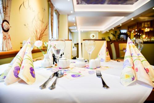 a table with a white table cloth and fork and knife at Hotel Zum Stern Spreewald in Werben