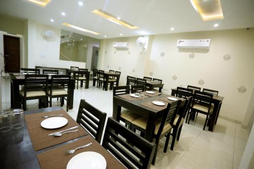 a dining room with wooden tables and chairs at Hotel Fortune Plaza in Ajmer