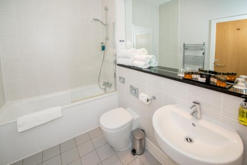 a white bathroom with a sink and a toilet at Stanwell Hotel By Mercure in Stanwell