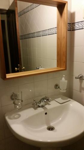 a bathroom sink with a mirror and a sink at Nossa Casa na Aldeia in Viseu