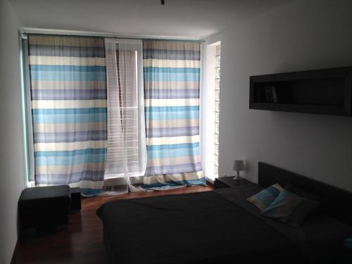 a bedroom with a bed and two large windows at Luksusowy apartament w Ustroniu in Ustroń