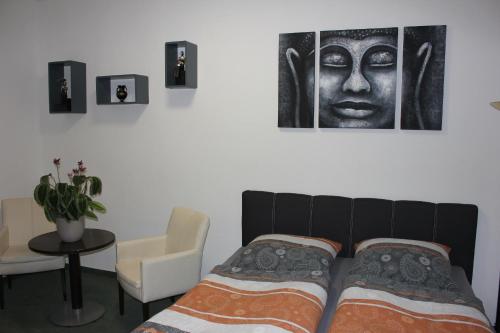 - une chambre avec un lit et une photo d'un buddha dans l'établissement Ferienwohnung Bonita, à Freital
