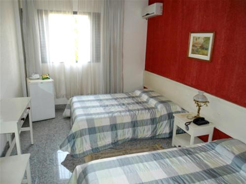 a hotel room with two beds and a window at Ancona Center Hotel in Amparo