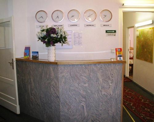 a lobby with a counter with clocks on the wall at Hotel Messe am Funkturm in Berlin