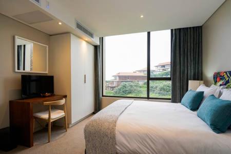 a hotel room with a large bed and a window at Zimbali Suite 205 in Ballito