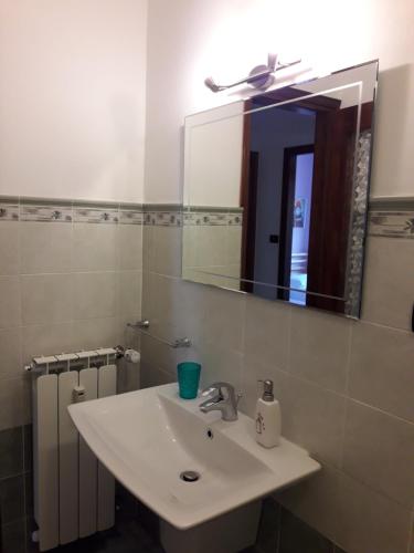 a bathroom with a white sink and a mirror at Appartamento Elisa - CIR 0226 in Aosta