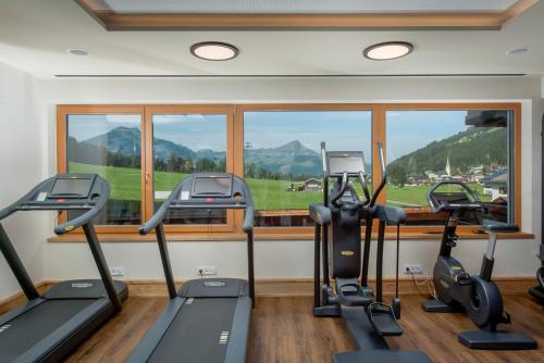 a gym with treadmills and ellipticals in front of a window at Hotel Kitzspitz in Sankt Jakob in Haus