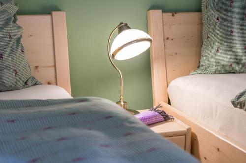 a lamp sitting on a night stand next to a bed at Ausseer Chalet (nahe Hallstatt), Ferienhaus in Bad Aussee