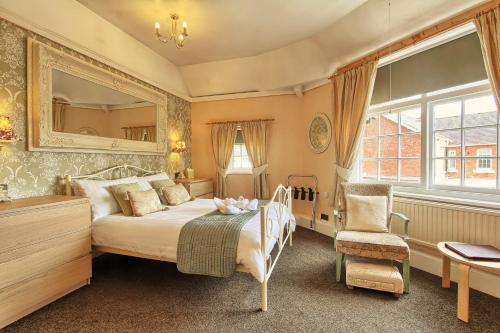 a bedroom with a bed and a mirror and a chair at The Stockton Arms Hotel in Stockton-on-Tees