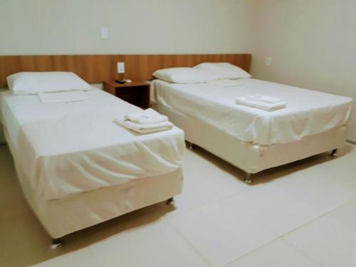 Chapadinha的住宿－Torre do Sol Park Hotel，两张位于酒店客房的床,配有毛巾