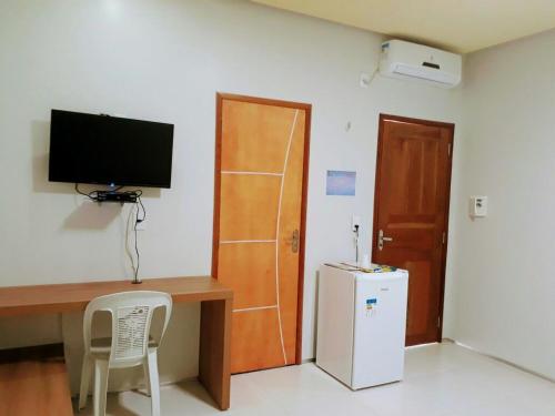 a room with a desk with a television and a refrigerator at Torre do Sol Park Hotel in Chapadinha