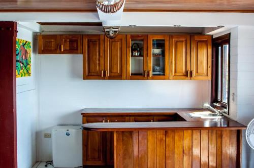 a kitchen with wooden cabinets and a sink at Magnific Rock - Surf Resort & Yoga Retreat Nicaragua in Popoyo