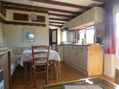 cocina y sala de estar con mesa y sofá en Domaine Le Bois de l'Espaud, en Tronget