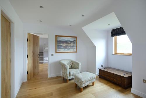 a living room with a chair and a table at Airds Bay Luxury Beach House in Gatehouse of Fleet