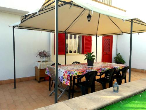 un tavolo e sedie sotto un ombrellone su un patio di Garden House Airport a Napoli