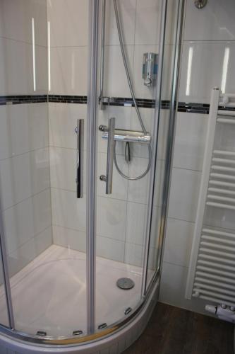 a shower with a glass door in a bathroom at Gaestehaus Bachmann in Dutenhofen
