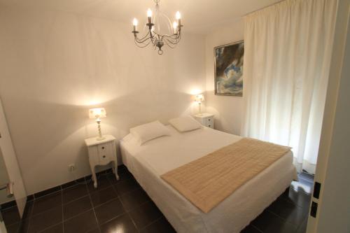 a bedroom with a bed and a chandelier at Alpilles Villa Serena in Saint-Rémy-de-Provence