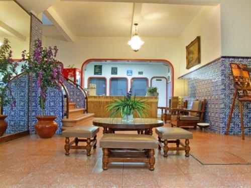 ein Wohnzimmer mit einem Tisch und Stühlen sowie ein Zimmer mit einer Treppe in der Unterkunft Hotel Sierra de Alica in Tepic