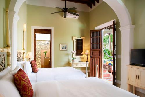 a bedroom with a white bed and white walls at Casa Lecanda Boutique Hotel in Mérida