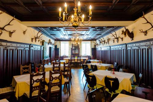 a dining room with tables and chairs and a chandelier at Landhotel Groggerhof in Obdach