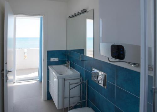 ein Badezimmer mit einem WC, einem Waschbecken und einem Spiegel in der Unterkunft DELPOSTO Marina di Ragusa DS in Marina di Ragusa