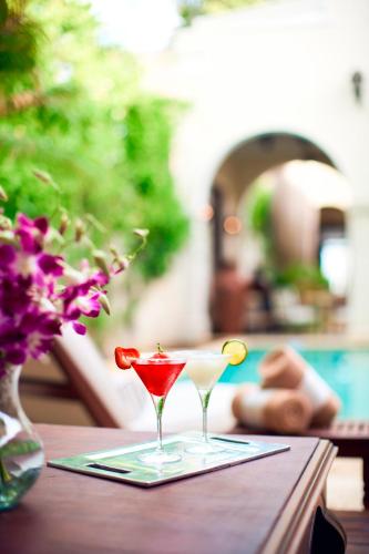 two martini glasses sitting on a wooden table at Casa Lecanda Boutique Hotel in Mérida