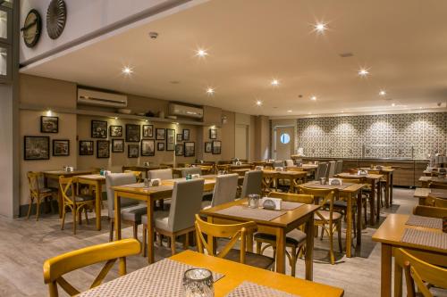 クリシウマにあるTri Hotel Premium Criciúmaの部屋にテーブルと椅子があるレストラン