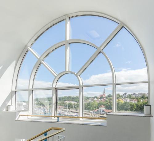 an arched window with a view of a city at Ramada by Wyndham Flensburg City in Flensburg