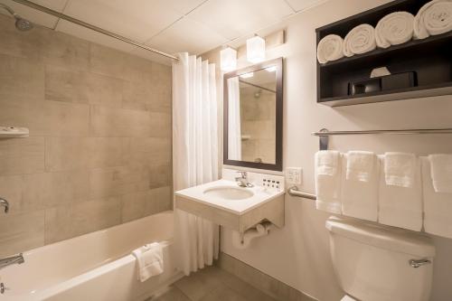 ein weißes Badezimmer mit einem Waschbecken und einer Badewanne in der Unterkunft Country Inn & Suites by Radisson, Rochester-Pittsford-Brighton, NY in Rochester