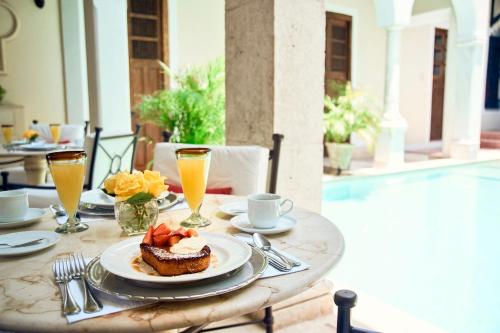 a table with a plate of food and drinks at Casa Lecanda Boutique Hotel in Mérida