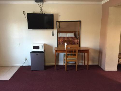 una camera d'albergo con tavolo e letto di Mission Motel a Lynwood