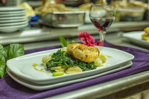a plate of food on a table with a glass of wine at Bocawina Rainforest Resort in Hopkins