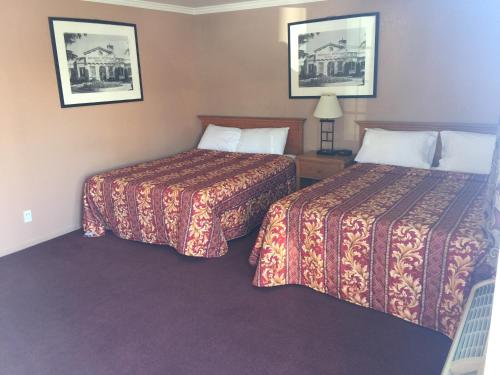 a hotel room with two beds and two lamps at Mission Motel in Lynwood