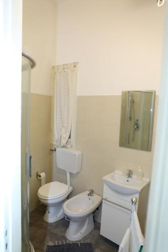 a white bathroom with a toilet and a sink at Appartamenti al Porto in Trapani